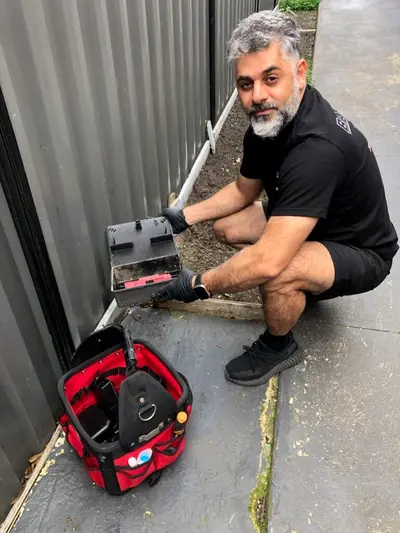 Robin from Babylon Pest Control servicing an external rodent bait station